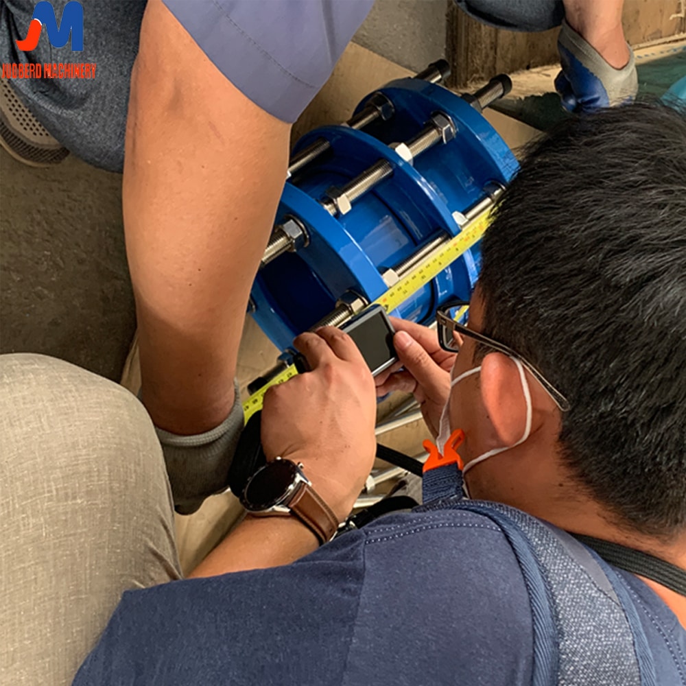 Engineer measuring a pipe for a dismantling joint