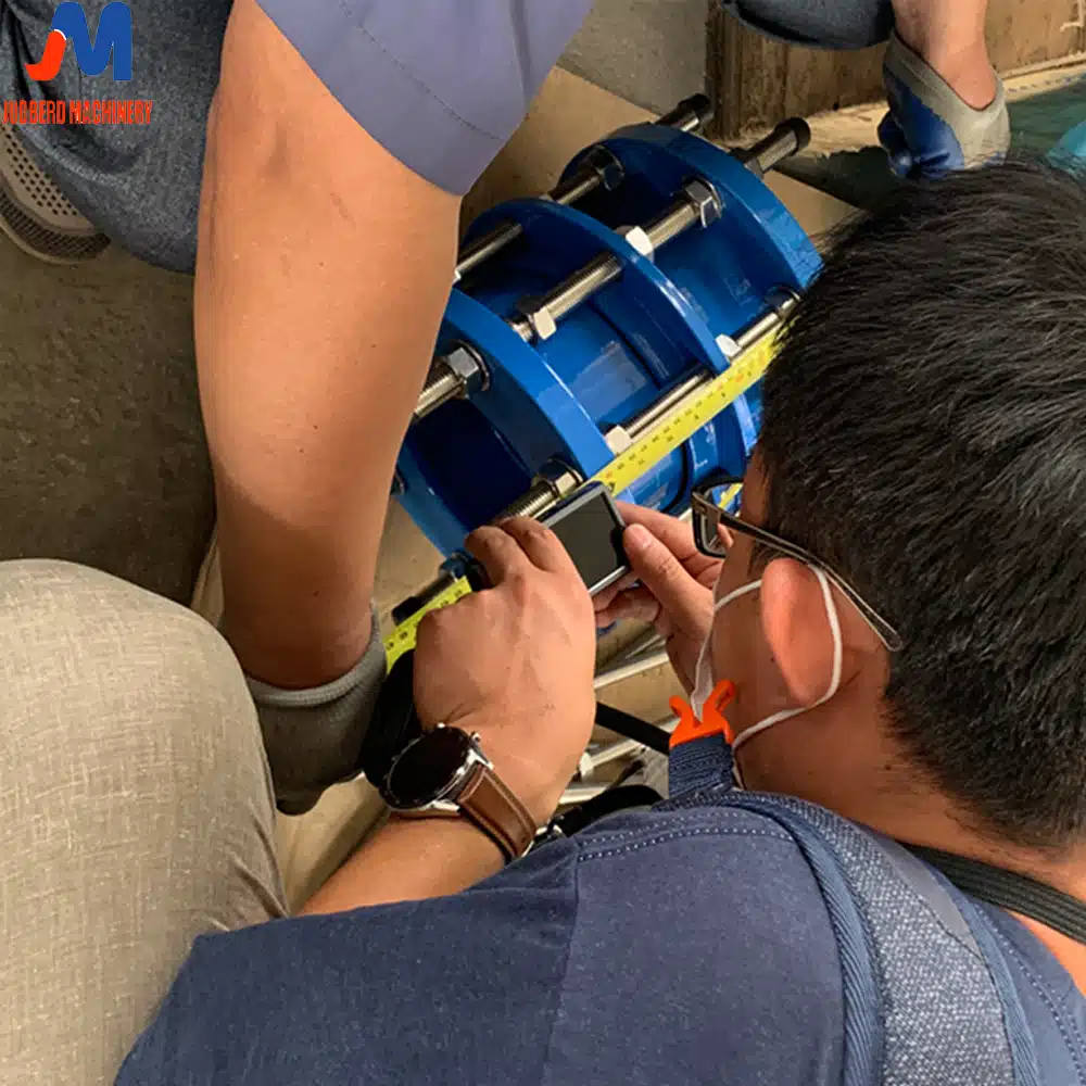 Engineer measuring a pipe for a dismantling joint