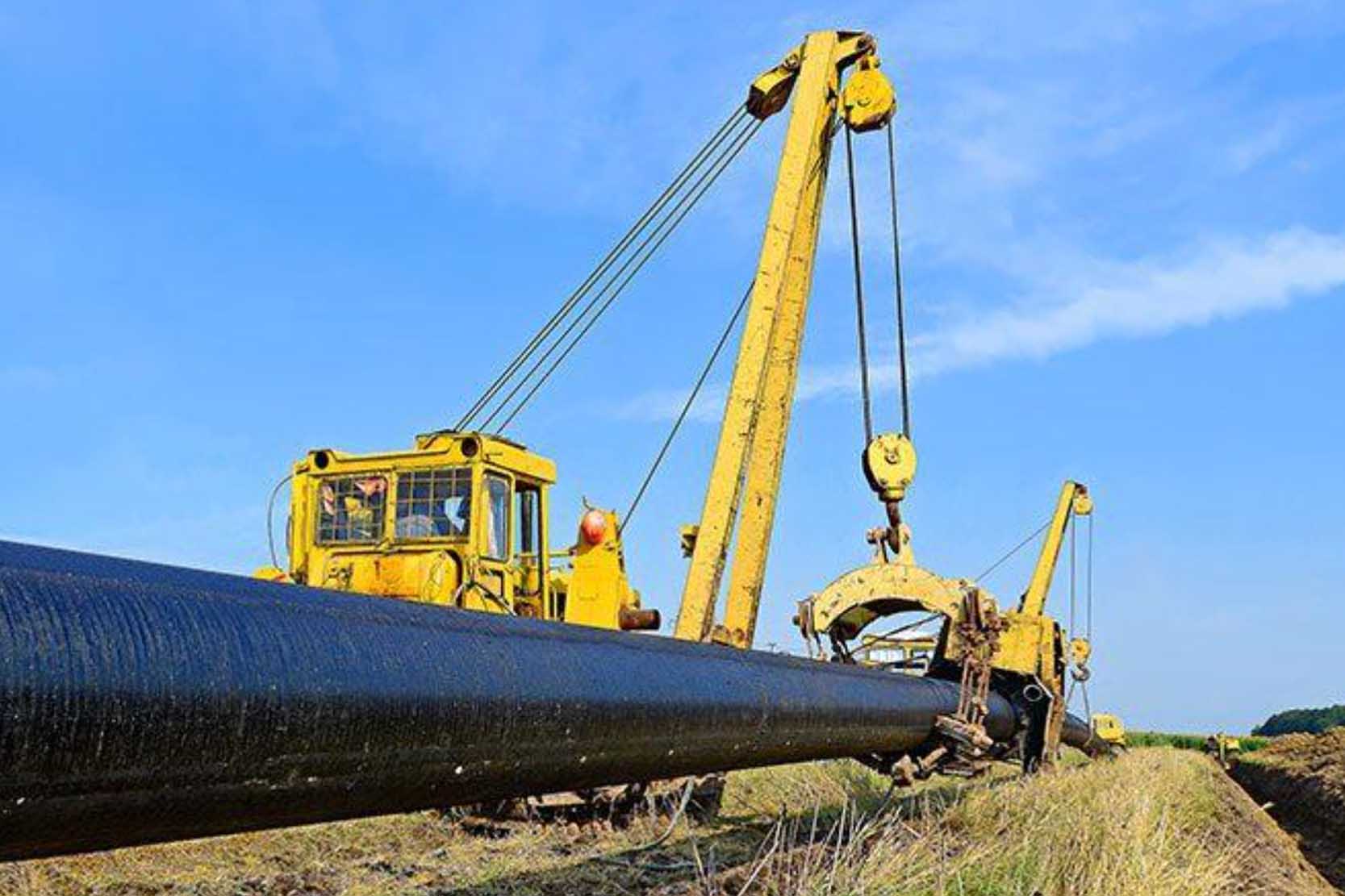 A crane lifting a new section of pipe into place