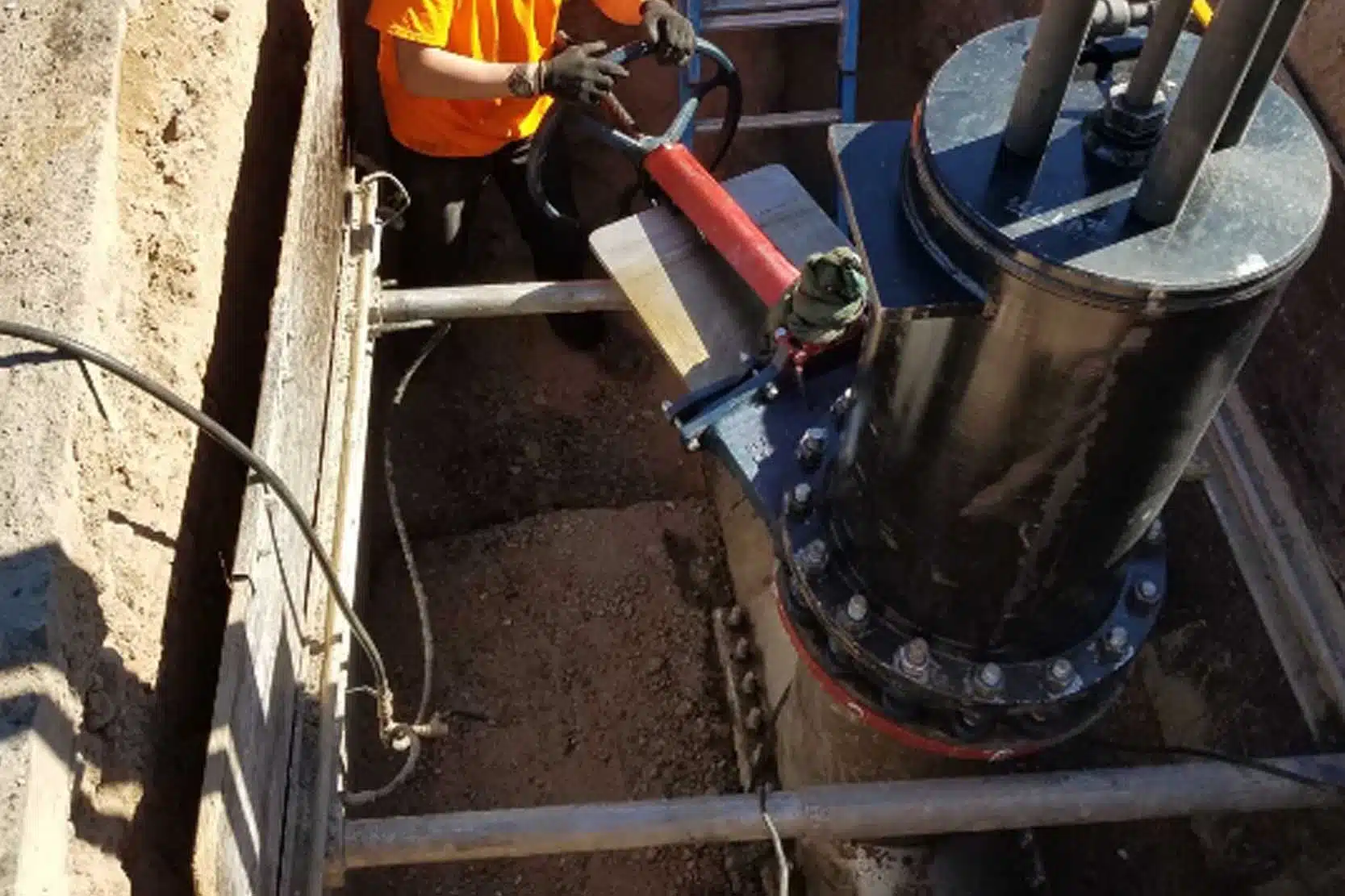 A team performing a hot tapping procedure on a large water pipeline