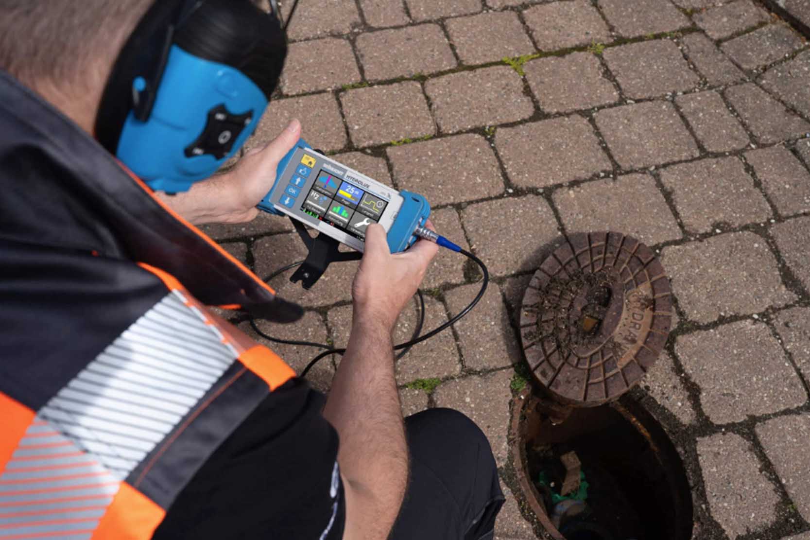 Engineer using acoustic leak detection equipment on a pipeline