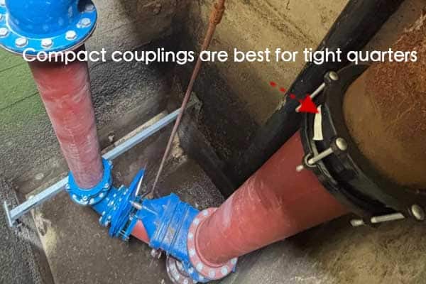 A worker installing a pipe coupling in a tight trench