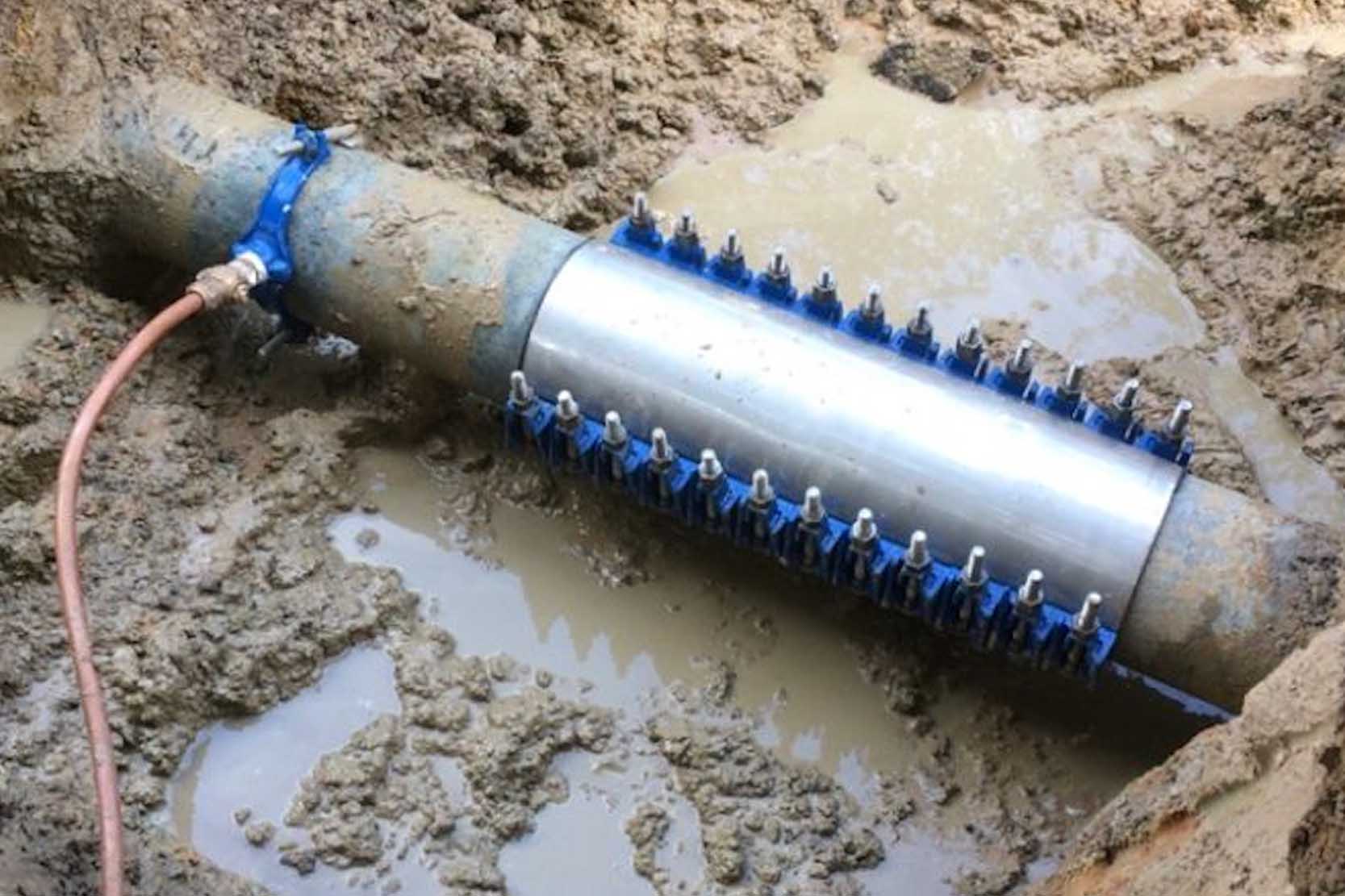 A stainless steel repair clamp installed on a leaking water pipe