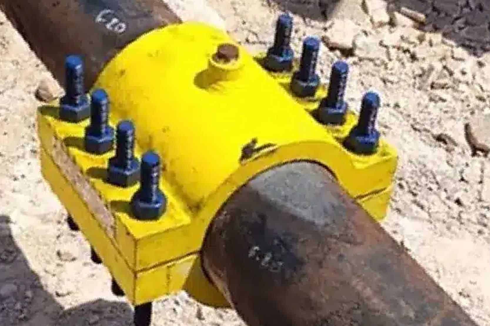 A strong stainless steel clamp being installed on a corroded steel pipe