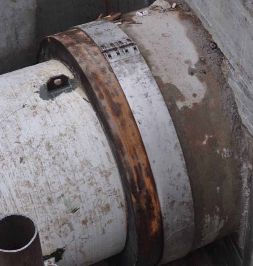 A temporary pipe clamp next to a new pipe section